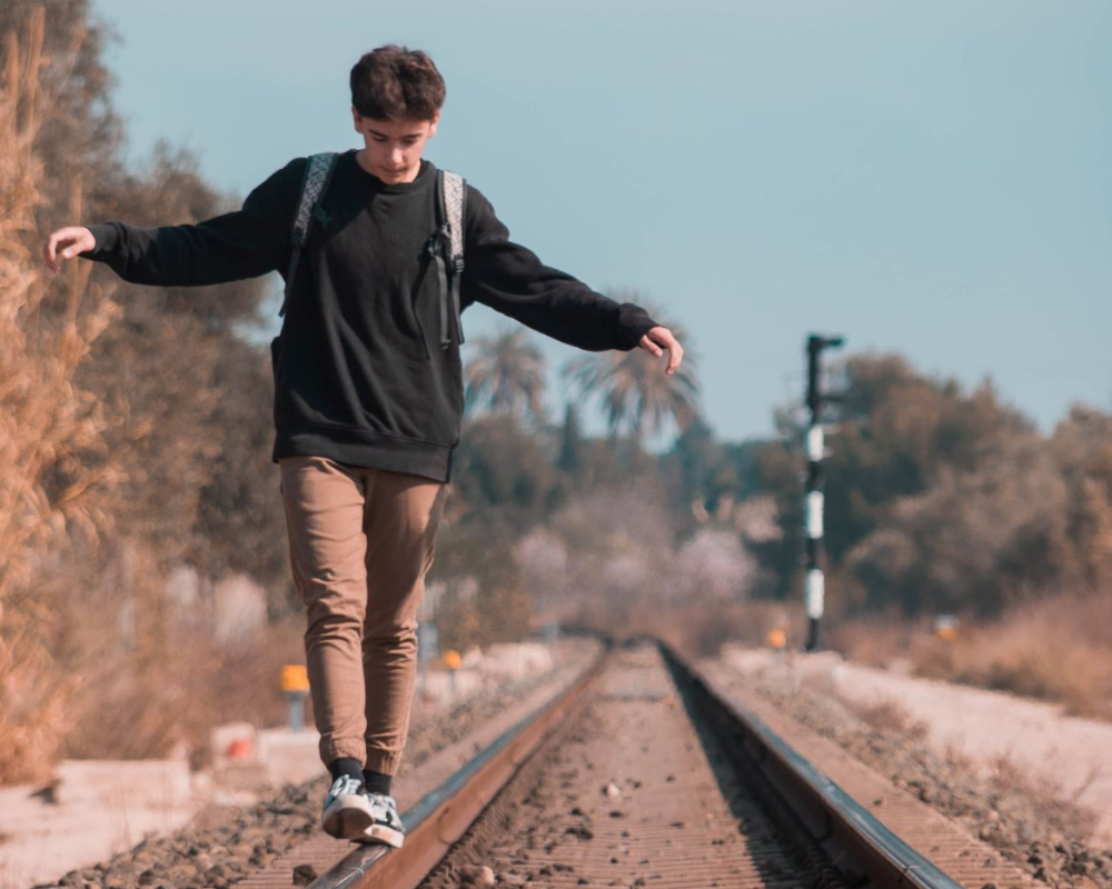 boy balancing on tracks