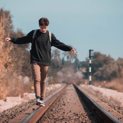 boy balancing on tracks