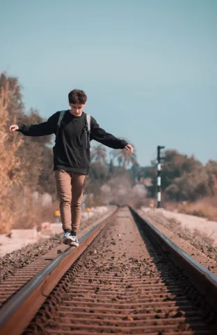 boy balancing on tracks